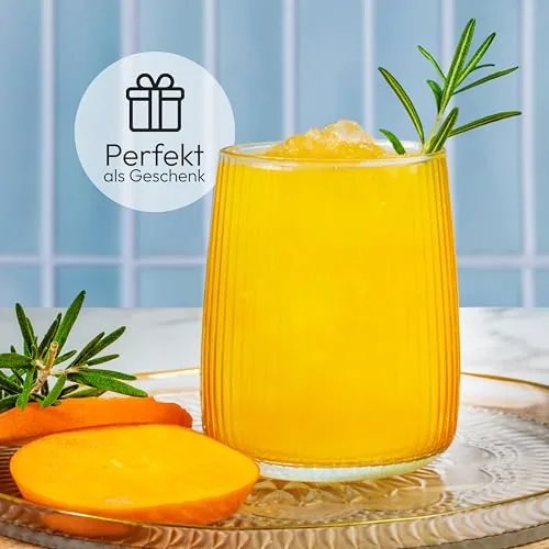 Glas mit gelbem Getränk, Rosmarin und Mangoscheiben vor blauer Wand